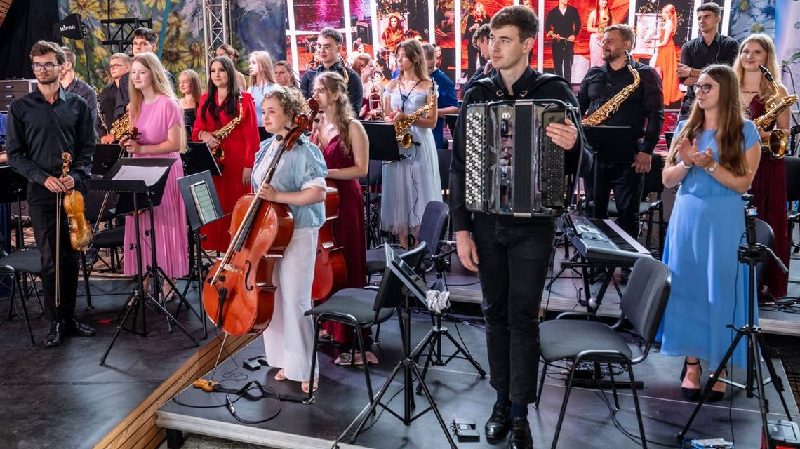 grupa młodych osób z instrumentami muzycznymi na scenie