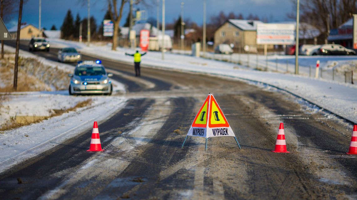 zdjęcie może przedstawiać znak wypadek na jezdni, w tle policjant