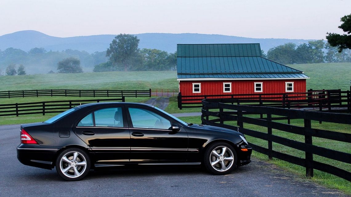 zdjęcie przedstawia samochód stojący pod płotem