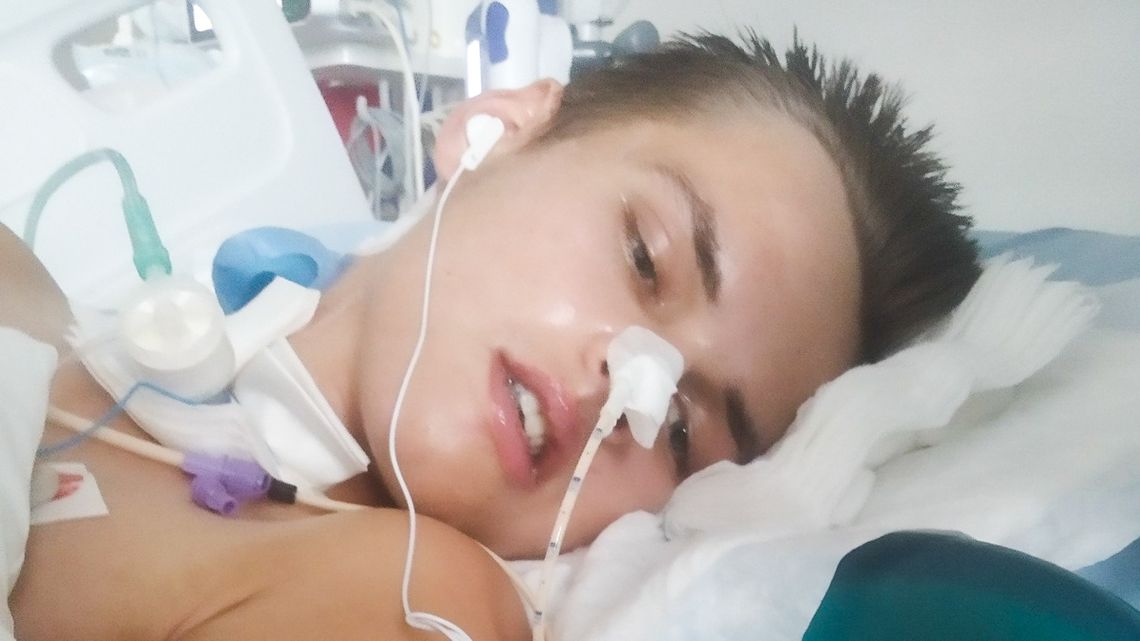 Chory chłopiec leży na łóżku w szpitalu
