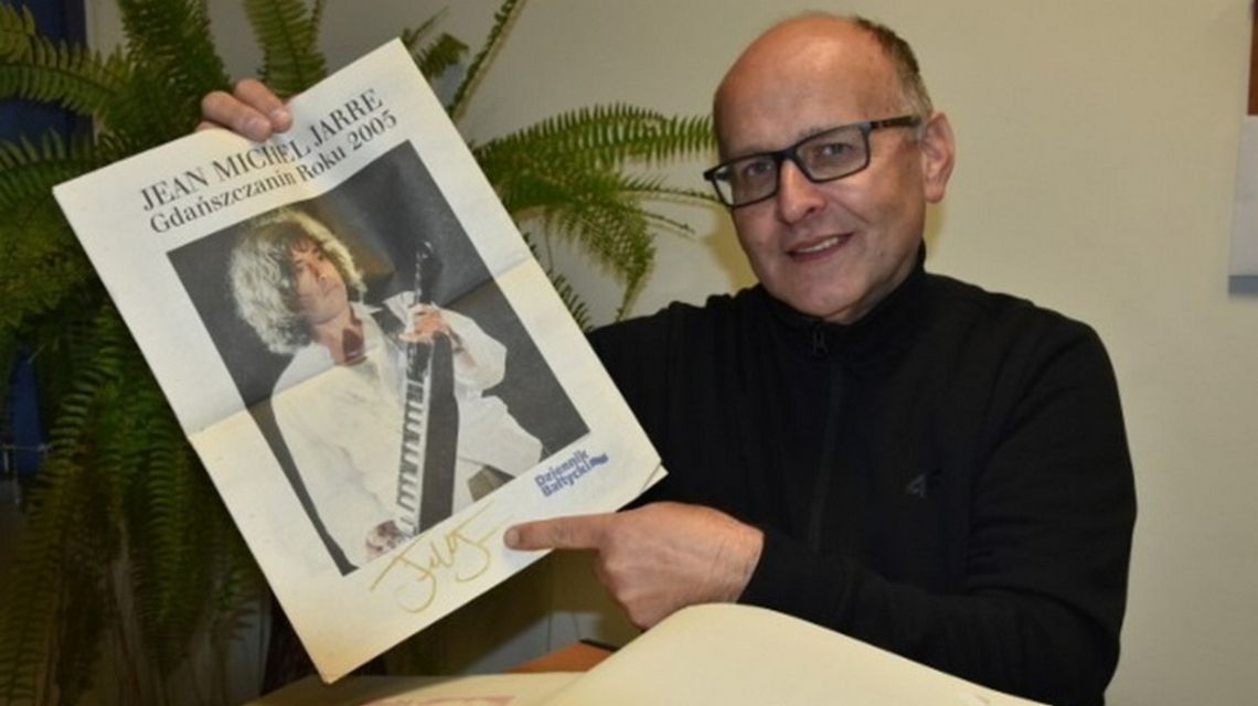 zdjęcie przedstawia mężczyznę z plakatem w ręce