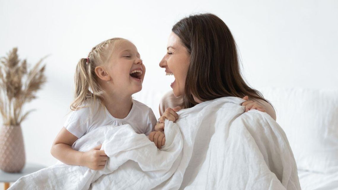 Zdjęcie przedstawia matkę z córką śmiejące się