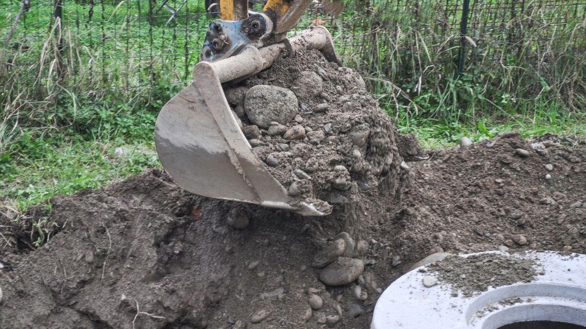 zdjęcie przedstawia łyżkę koparki z ziemią