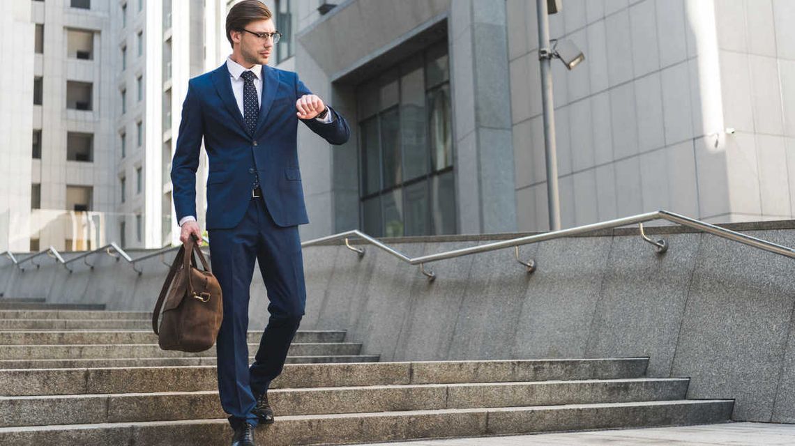 zdjęcie przedstawia mężczyznę w garniturze schodzącego po schodach