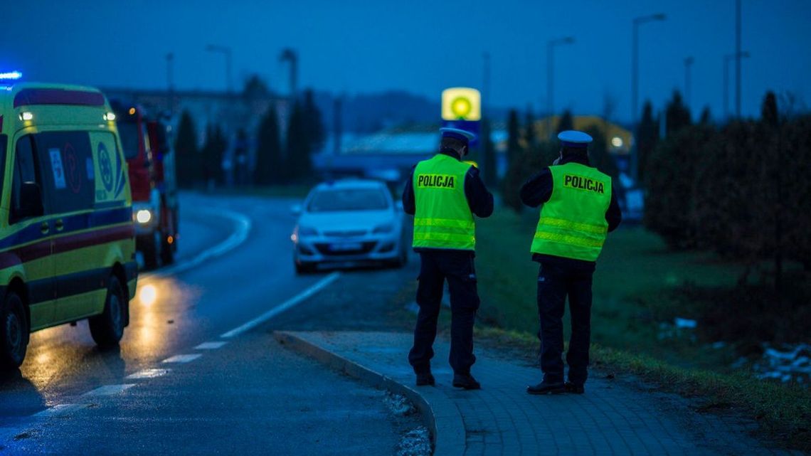 dwóch policjantów stojących tyłem na chodniku w gorlicach