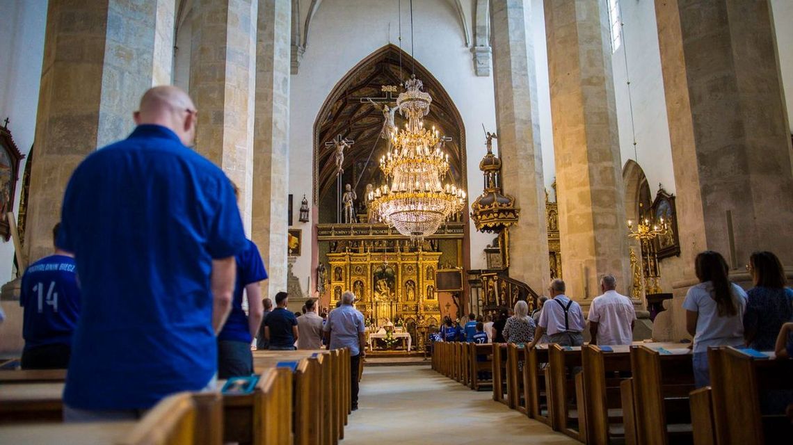 zdjęcie przedstawia wnętrze kościoła z ławkami i ołtarzem na pierwszym planie