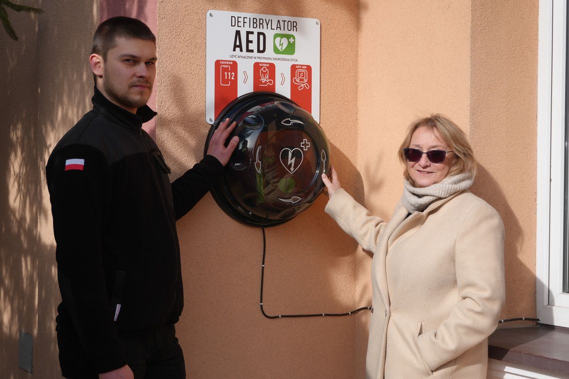 zdjęcie przedstawia kobietę i mężczyznę trzymających ręce na kapsule na ścianie