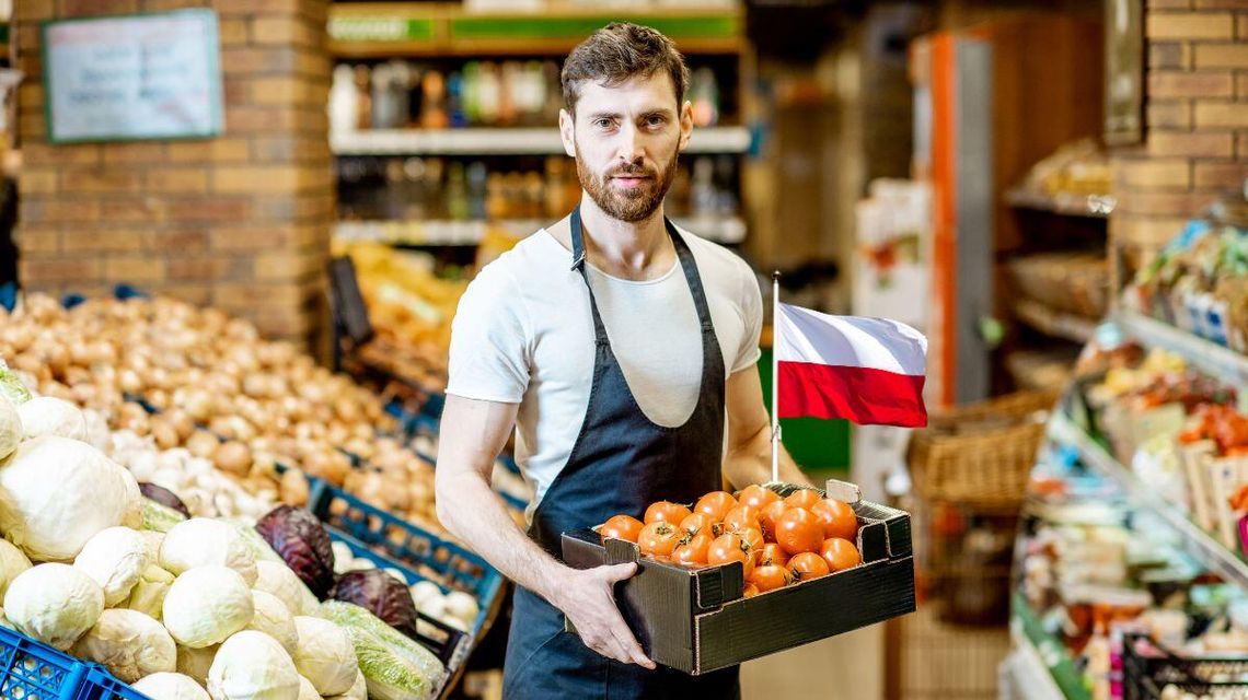 zdjęcie przedstawia pana w sklepie niosącego warzywa