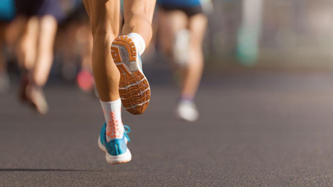 zdjęcie przedstawia biegnących po asfalcie