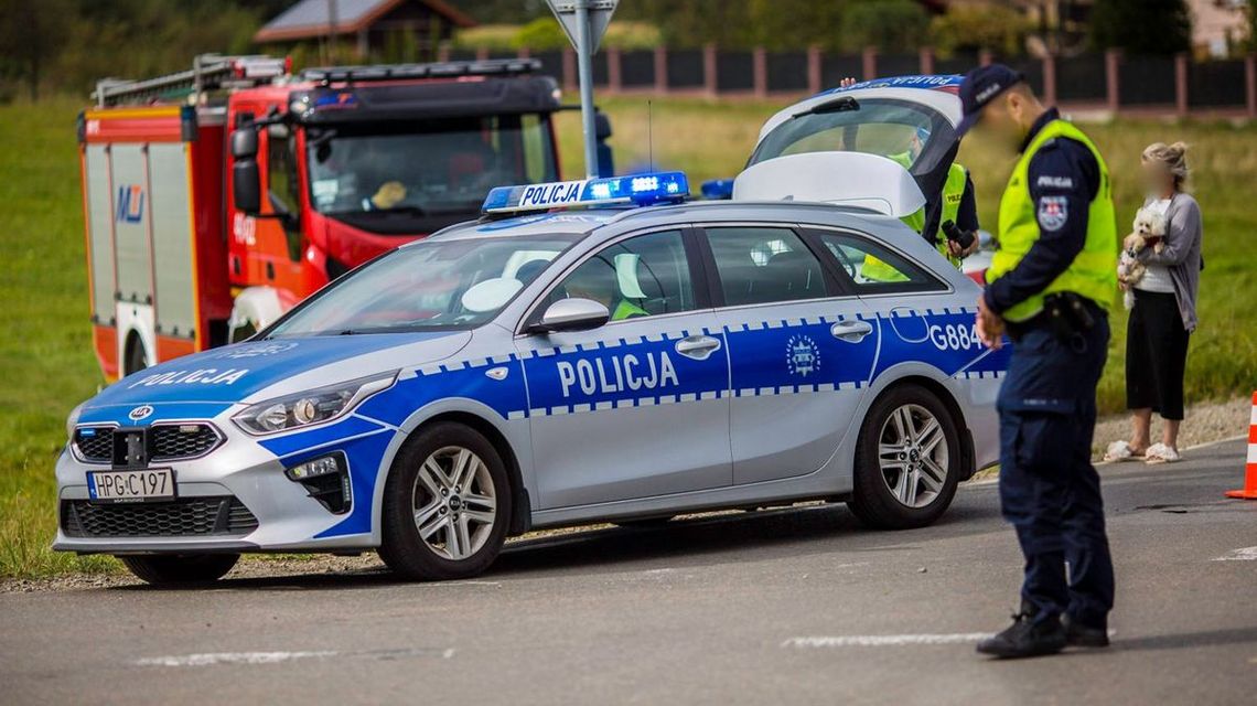 policjant stojący na tle radiowozu