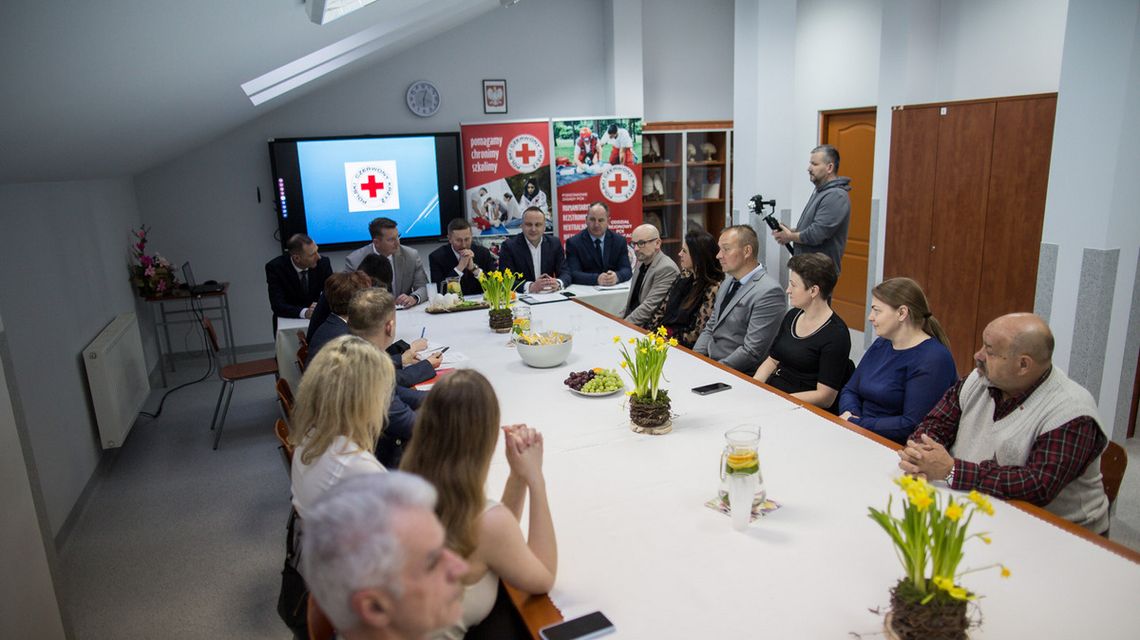 zdjęcie przedstawia grupę osób siedzących przy stole