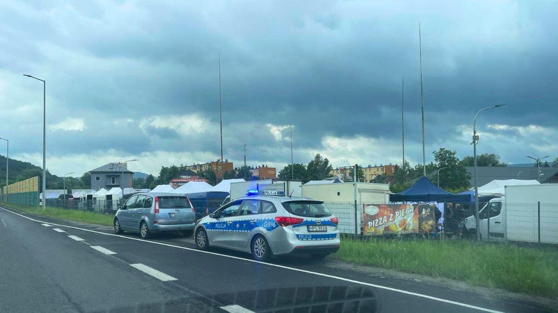 zdjęcie przedstawia policyjny radiowóz i pojazd stojący na poboczu ulicy