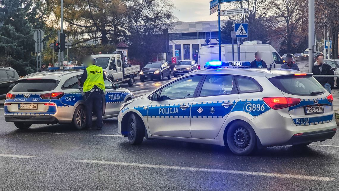 zdjęcie przedstawia dwa radiowozy policji na skrzyżowaniu