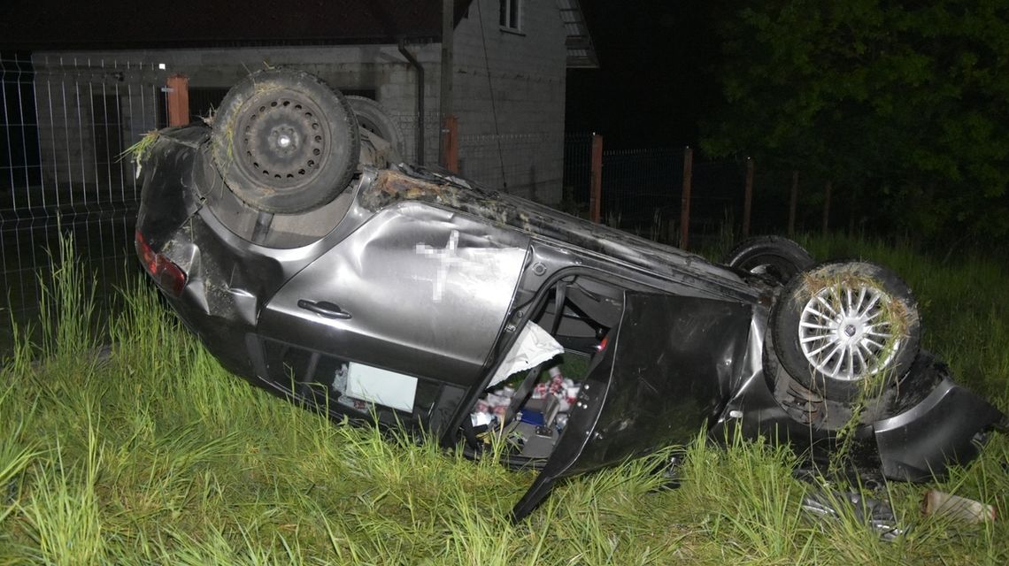 zdjęcie przedstawia samochód osobowy na dachu w rowie
