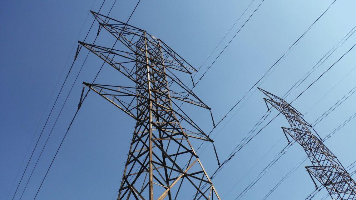 Zdjęcie przedstawia słupy elektryczne i niebo