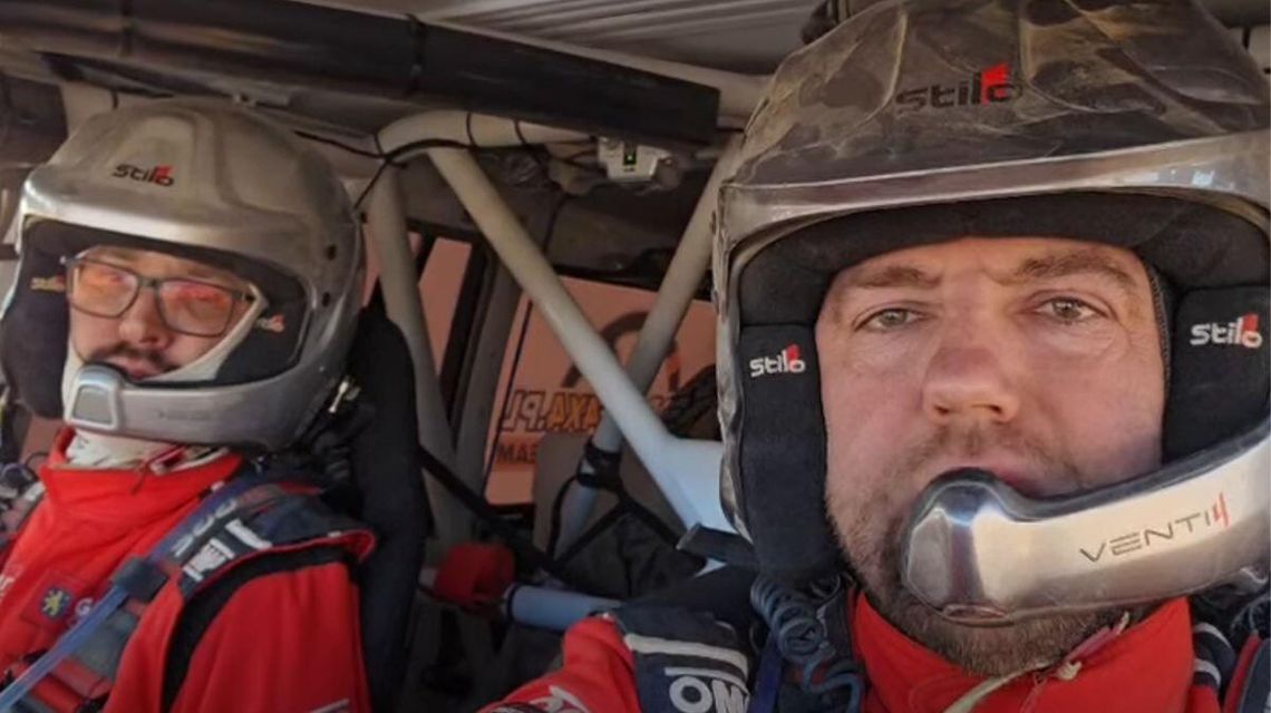 zdjęcie przedstawia dwóch mężczyzn w kaskach w samochodzie rajdowym