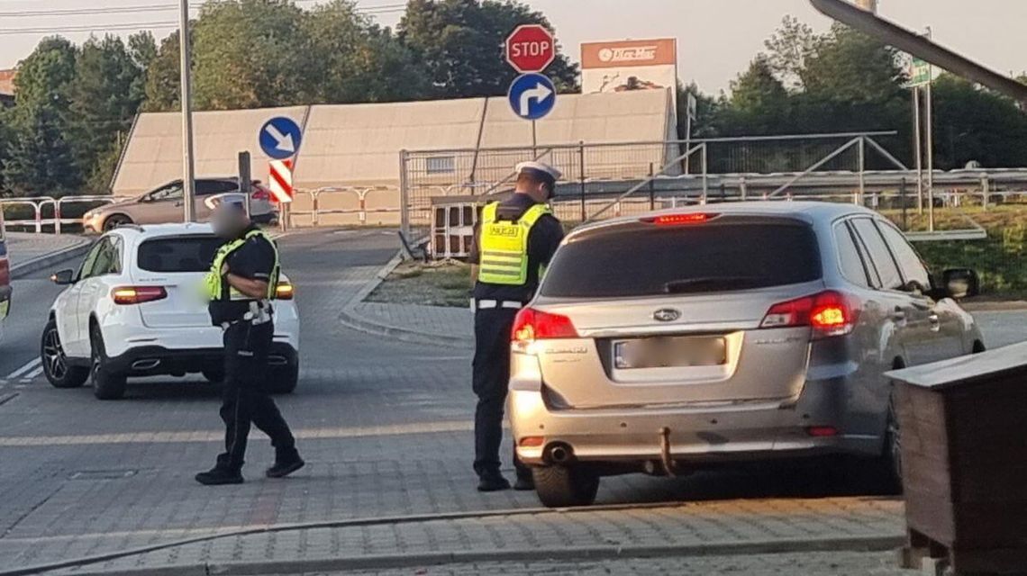 policjanci i stojący samochód na parkingu przy Jarmarku Pogórzańskim w Gorlicach