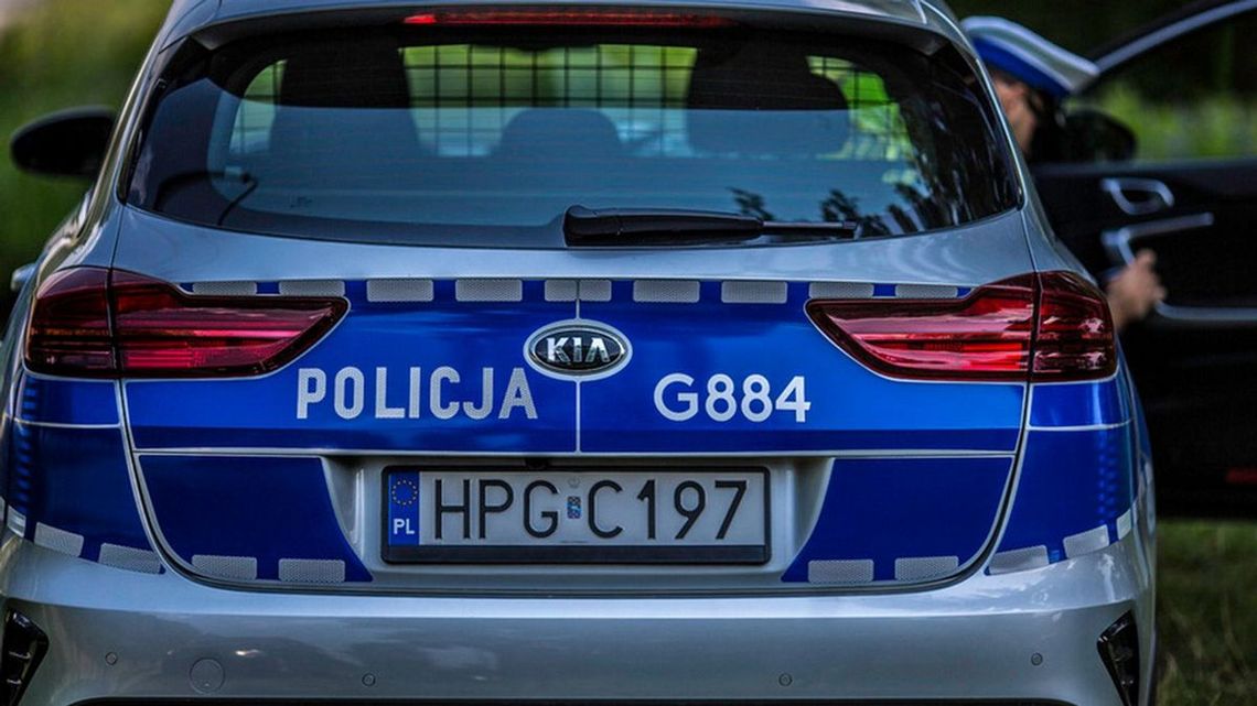 zdjęcie przedstawia policyjny radiowóz z którego wysiada policjant