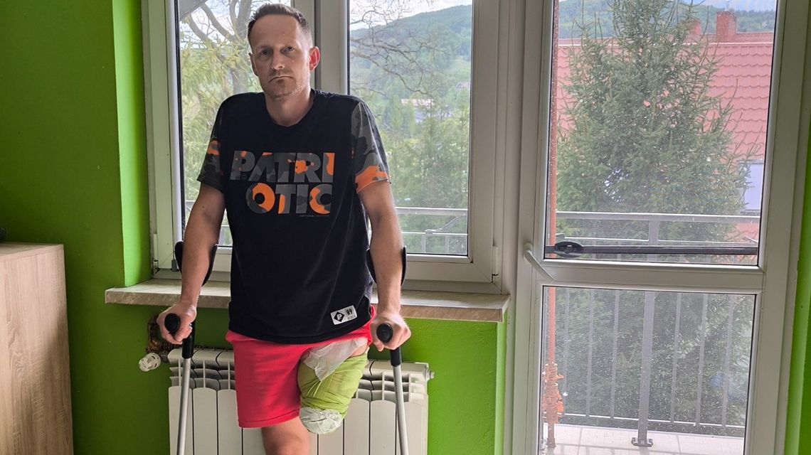 zdjęcie przedstawia mężczyznę podtrzymującego się na kulach