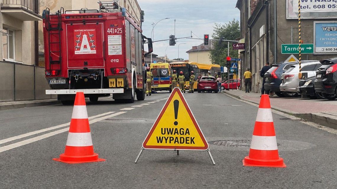 Ponad 100 wypadków ze skutkiem śmiertelnym od początku wakacji. Powiat gorlicki na mapie zdarzeń zdjęcie przedstawia wóz straży pożarnej karetkę pogotowia i autobus, na jezdni stoi znak i pachołki