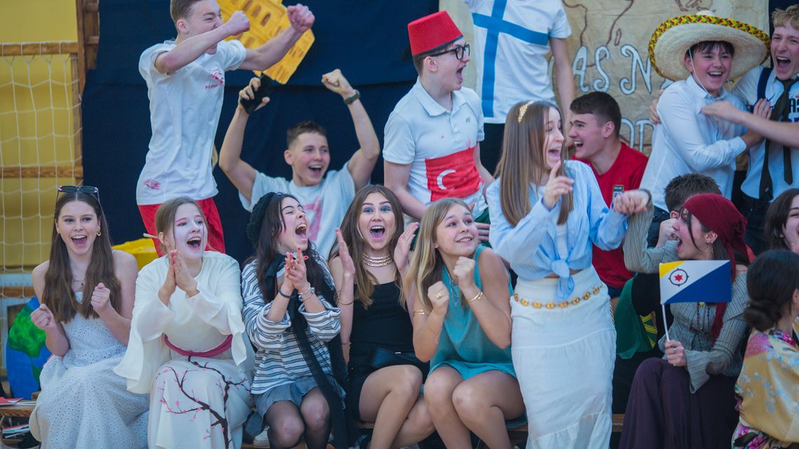 zdjęcie przedstawia grupę cieszących się dziewcząt i chłopców