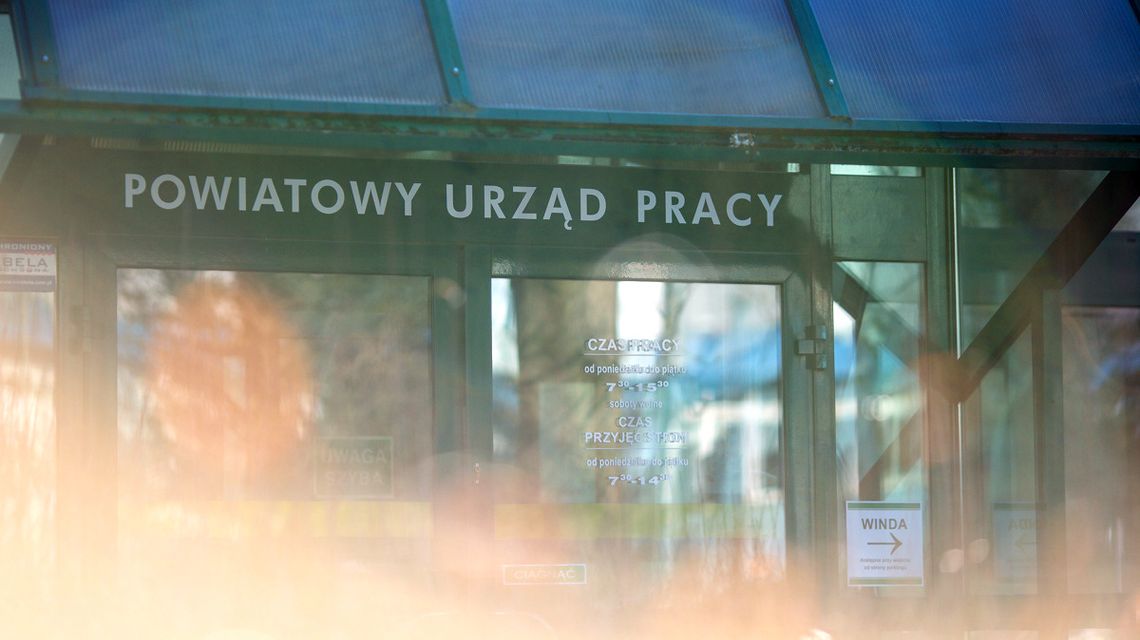zdjęcie przedstawia wejście do budynku ze szklanym wiatrołapem, na którym pisze powiatowy urząd pracy
