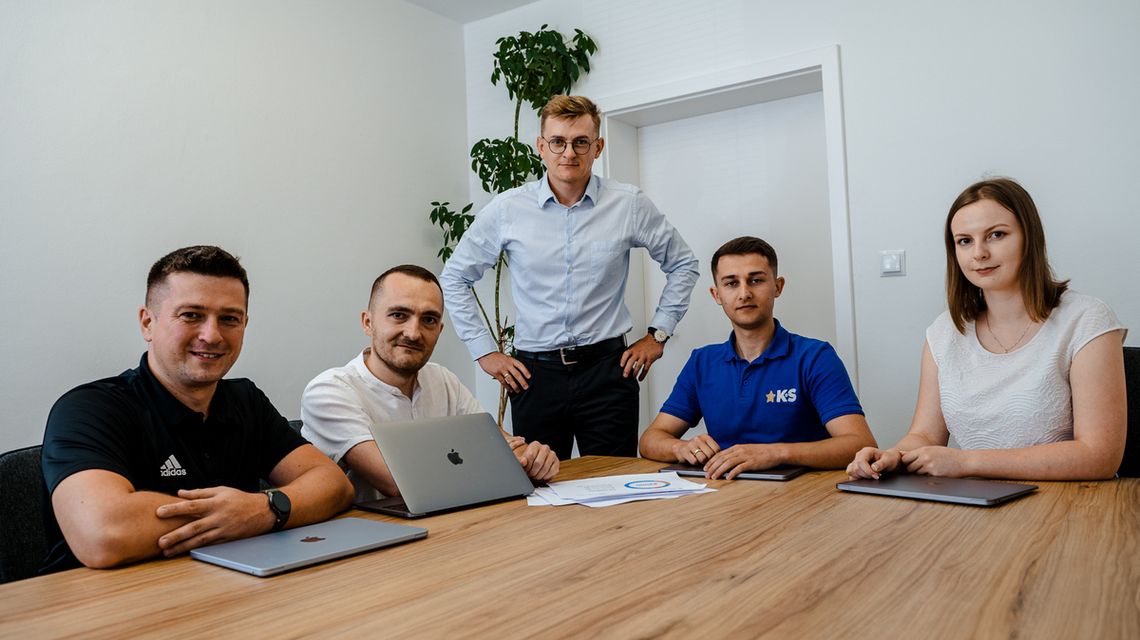 Praca w Agencji KS. Stabilne miejsce dla osób, które chcą rozwijać się w marketingu zdjęcie przedstawia grupę osób przy stole biurowym