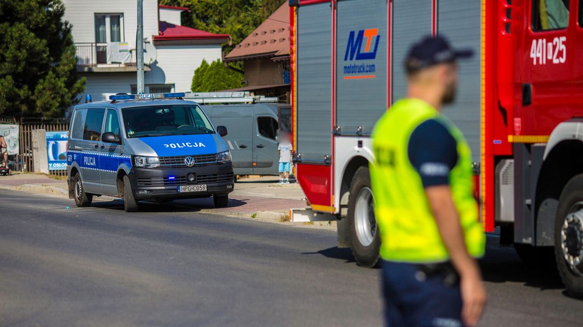 policyjny radiowóz na tle policjanta