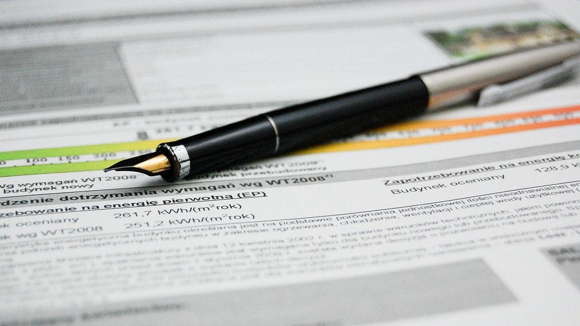 Remont a świadectwo energetyczne – czy po ociepleniu, wymianie okien lub źródła ciepła trzeba zrobić nowe? zdjęcie przedstawia pióro leżące na rachunku