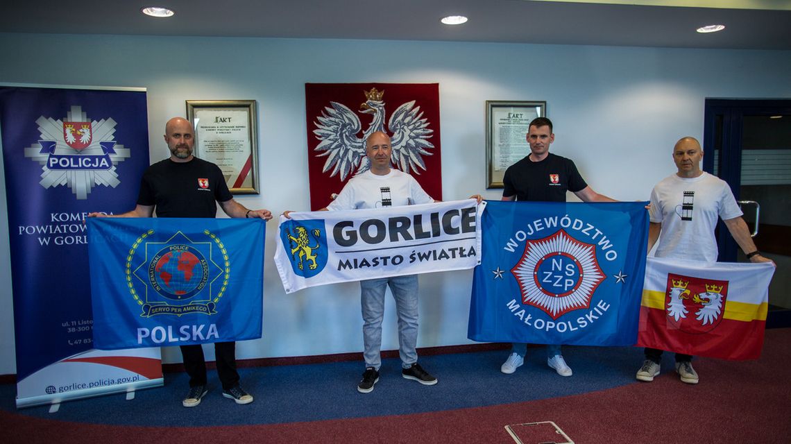 Rowerem przez Polskę dla chorej dziewczynki. Policjanci podsumowali akcję zdjęcie przedstawia kilku mężczyzn flagami