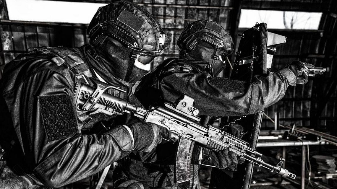 zdjęcie przedstawia policjantów w kominiarkach i z bronią