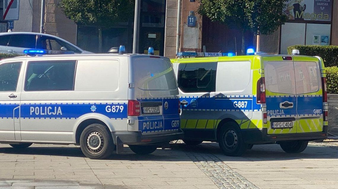 dwa radiowozy na płycie chodnikowej