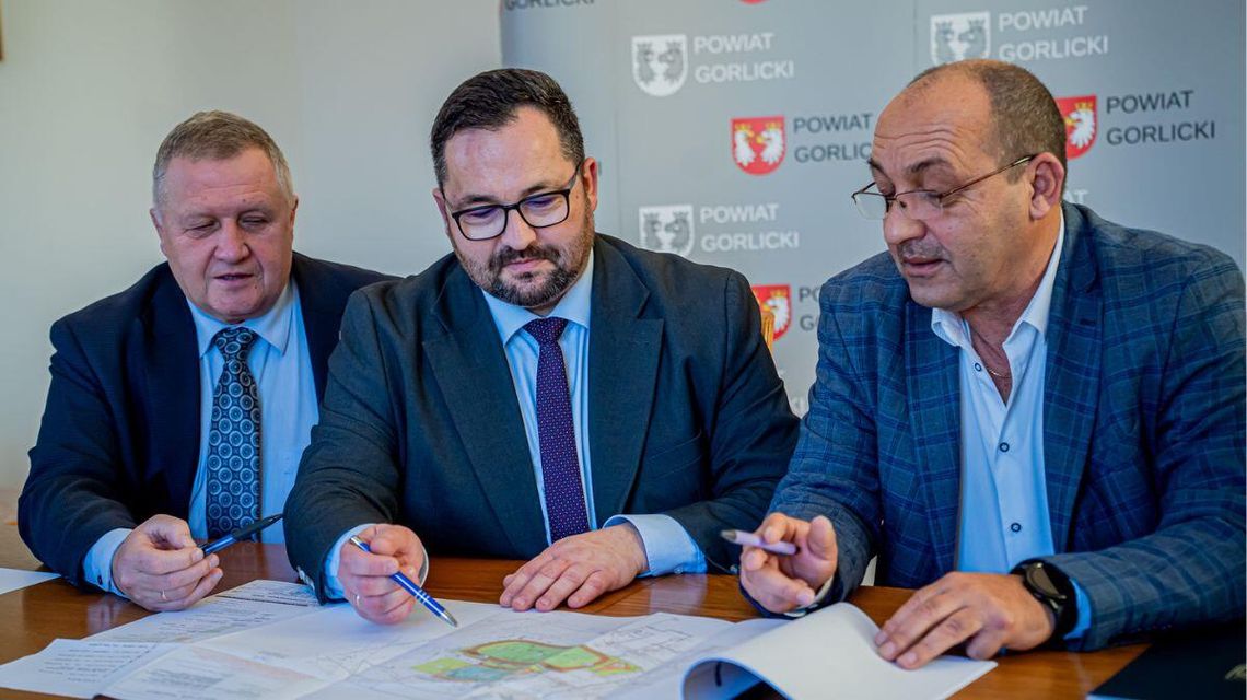 Zdjęcie przedstawia urzędników podpisujących umowy