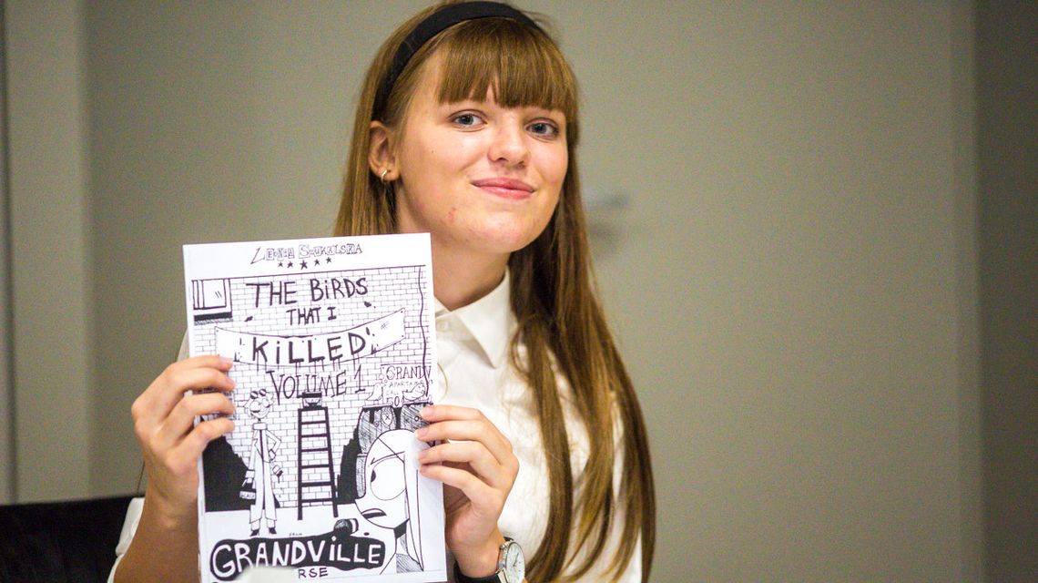 zdjęcie przedstawia dziewczynę z komiksem przed sobą