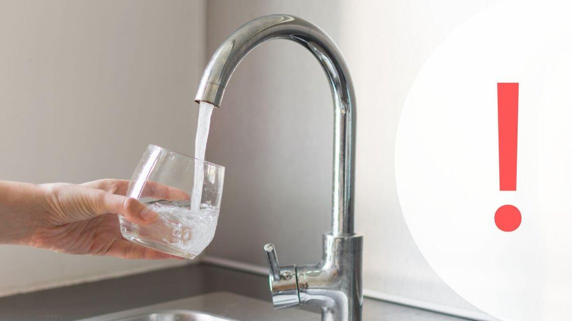 Zdjęcie przedstawia dłoń, która napełnia wodą z kranu szklankę