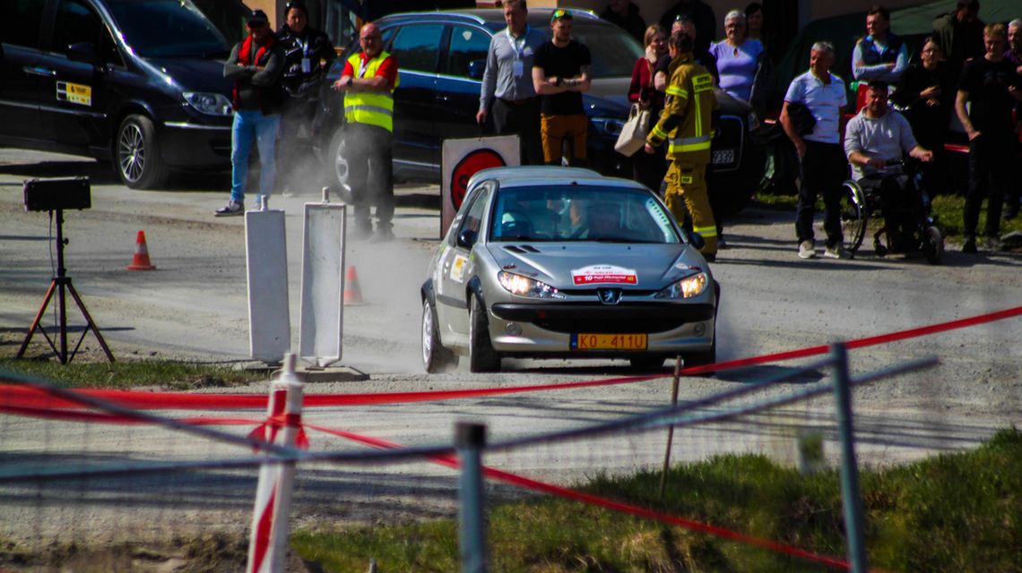 zdjęcie przedstawia samochód rajdowy na trasie, w tle widzowie