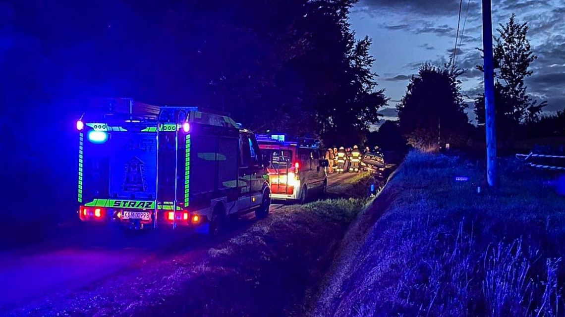 karetka pogotowia i wóz straży pożarnej oraz policji stojący na drodze w nocy