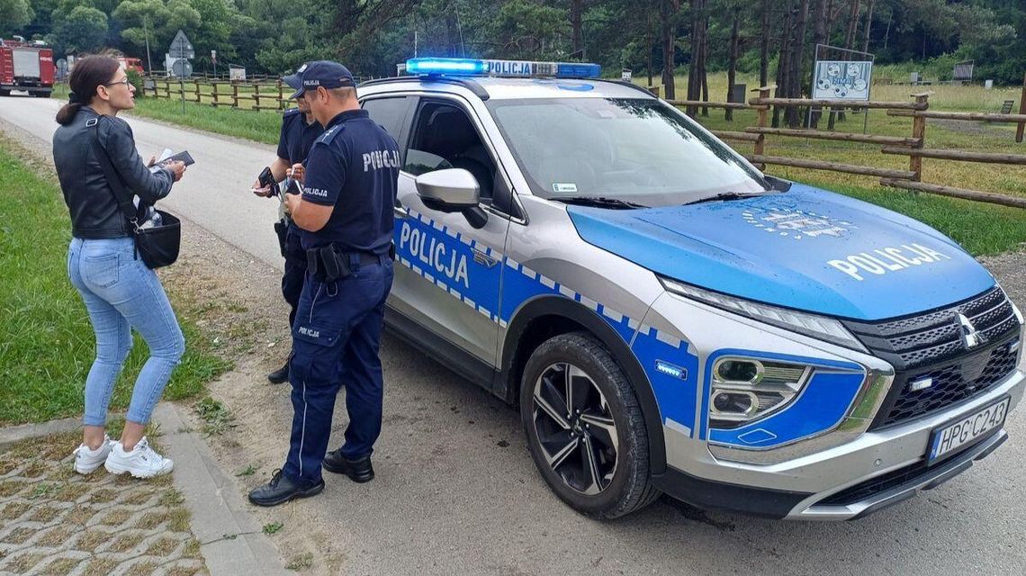 Zdjęcie przedstawia policjantów przy radiowozie