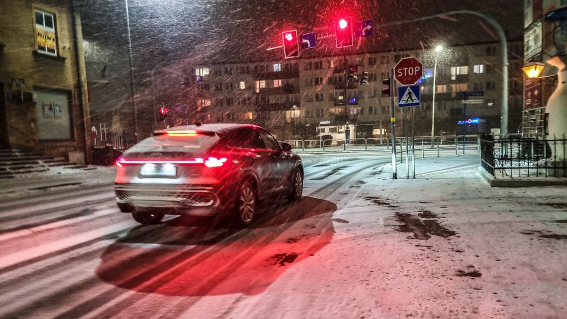 zdjęcie przedstawia samochód stojący na skrzyżowaniu w zimie
