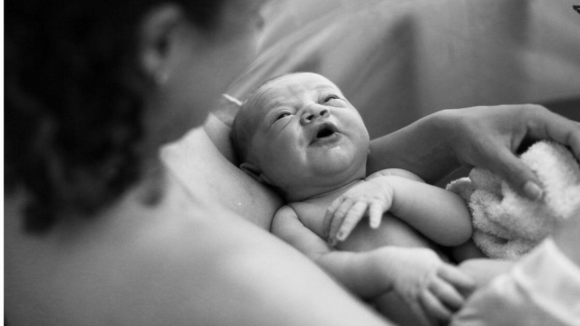 Zdjęcie przedstawia noworodka z mamą