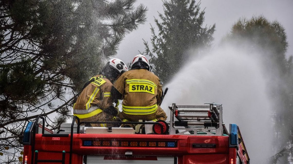 zdjęcie przedstawia strażaków na dach wozu bojowego