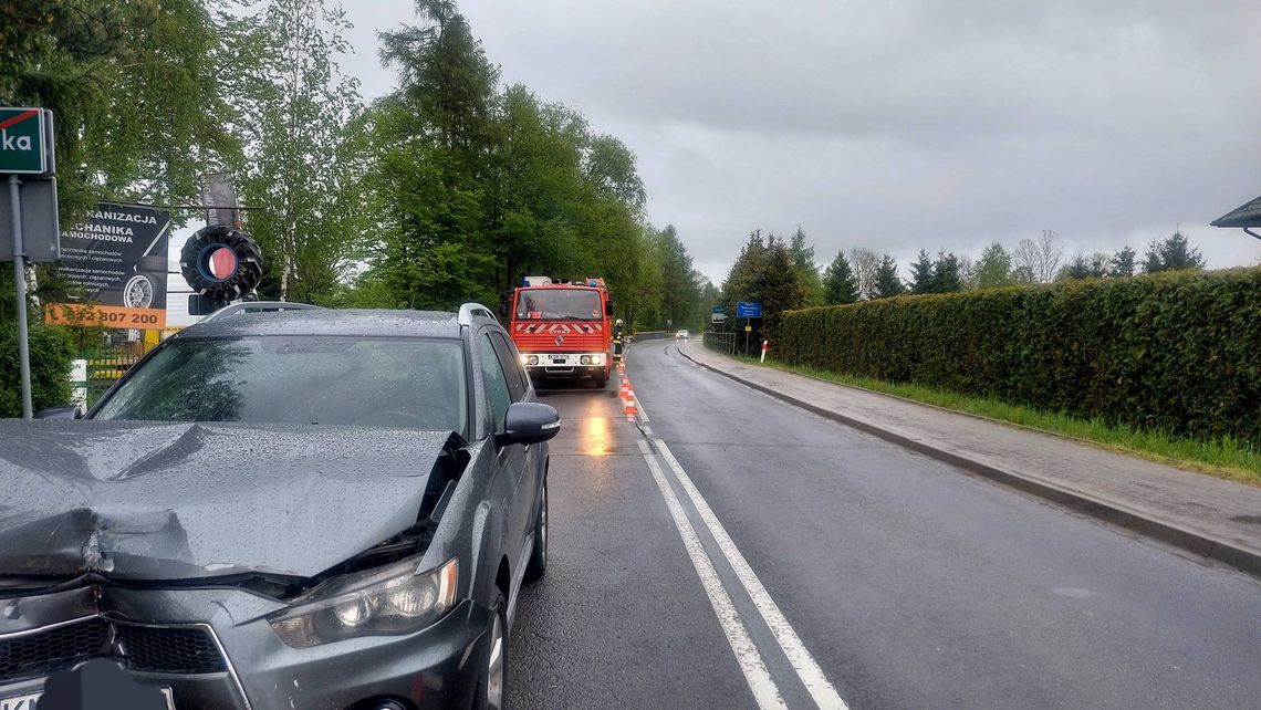 zdjęcie przedstawia uszkodzony pojazd na jezdni i za nią straż pozarną