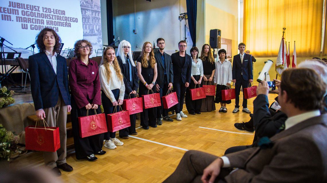 grupa osób z czerwonymi torbami