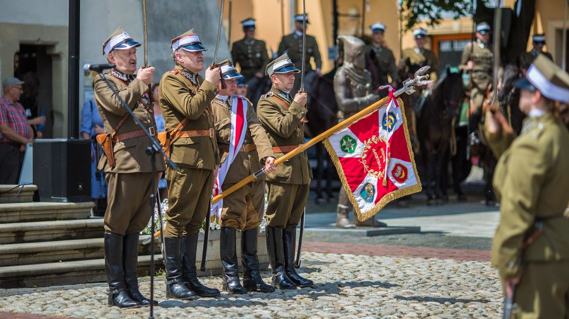 żołnierze trzymający szable i sztandar