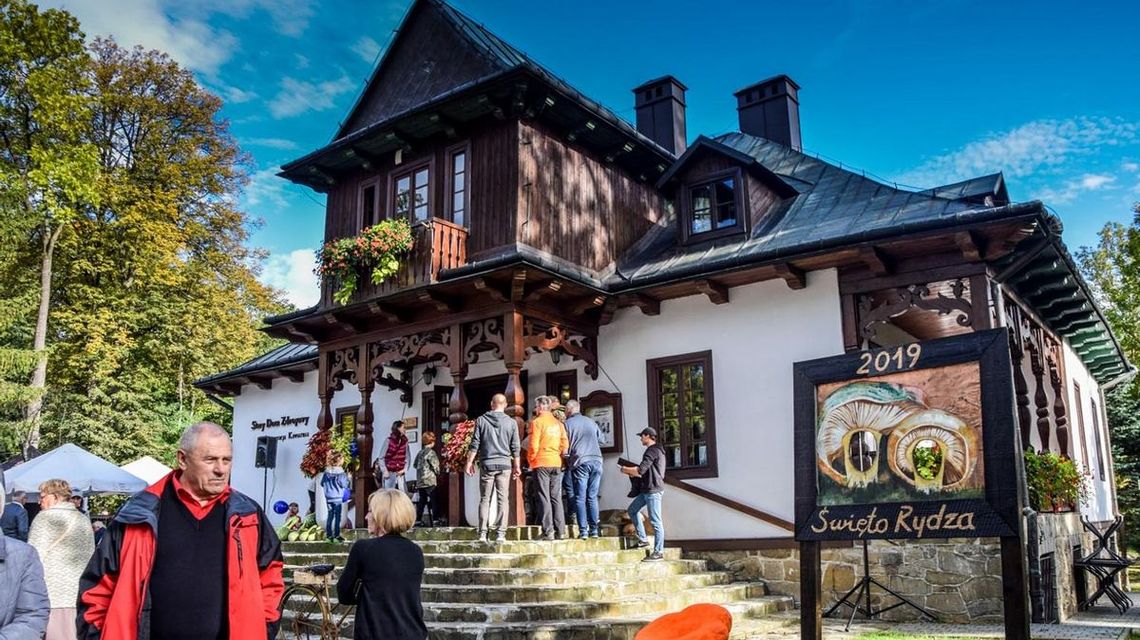 zdjęcie przedstawia budynek w otoczeniu drzew na schodach ludzie