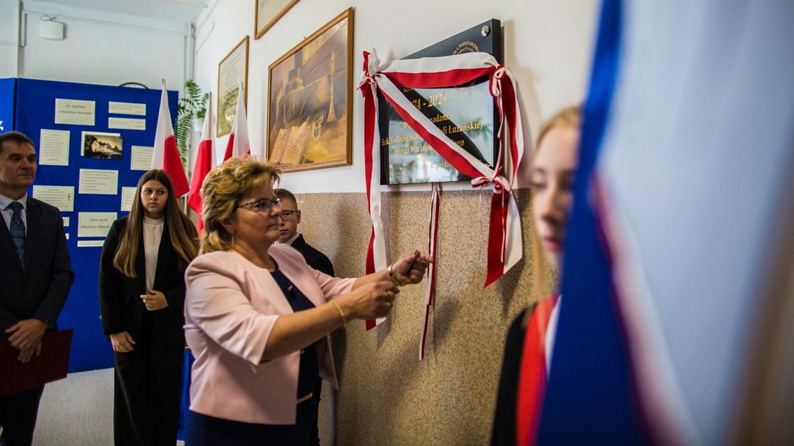 kobieta ściągająca wstążkę z tablicy