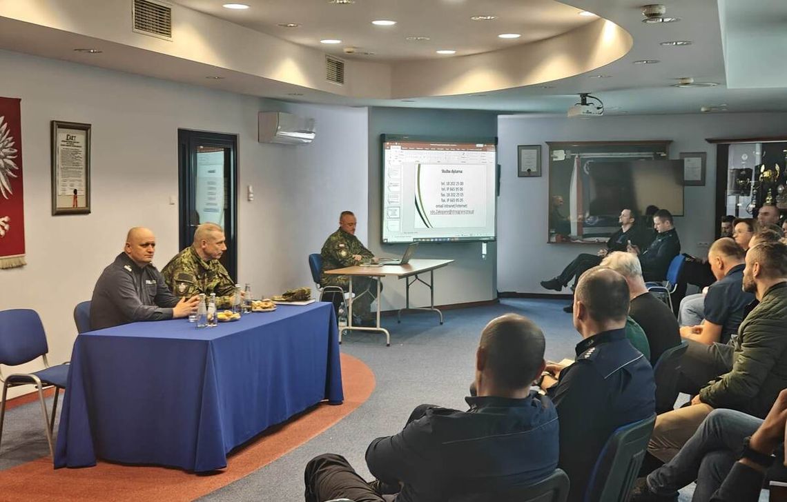 zdjęcie przedstawia policjantów i służby straży granicznej w budynku