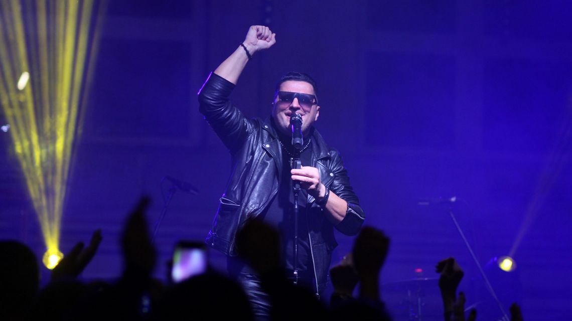 zdjęcie przedstawia mężczyznę w okularach przed mikrofonem