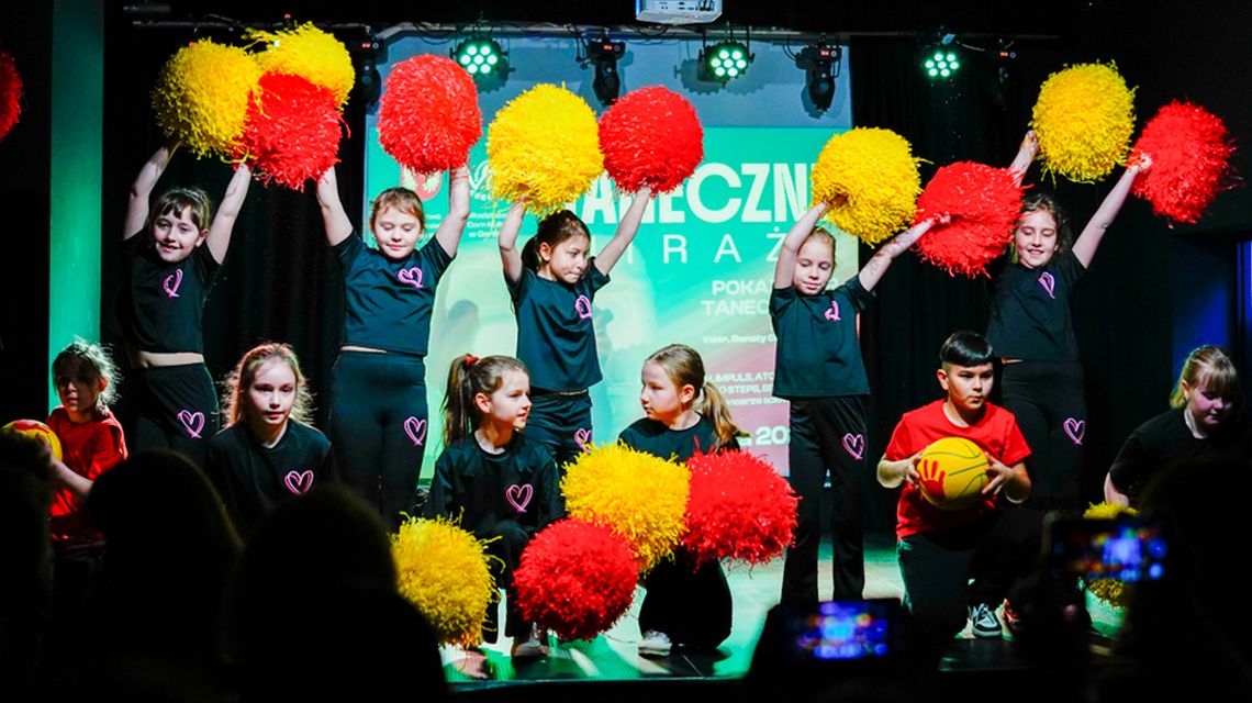 zdjęcie przedstawia tańczące dzieci z pomponami, na scenie MDK w Gorlicach