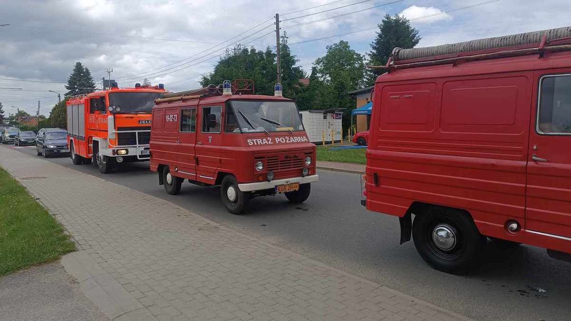 zdjęcie przedstawia stare samochody strażackie na drodze